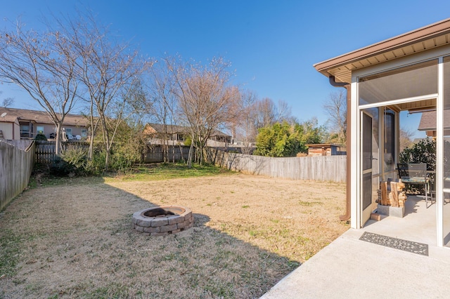 view of yard featuring a fenced backyard and a fire pit