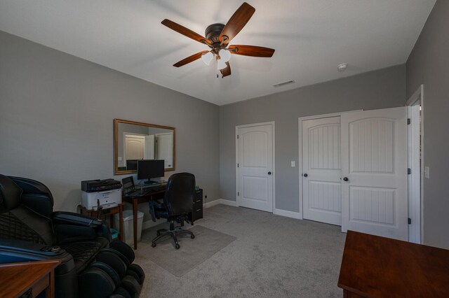 office area with carpet flooring, ceiling fan, visible vents, and baseboards