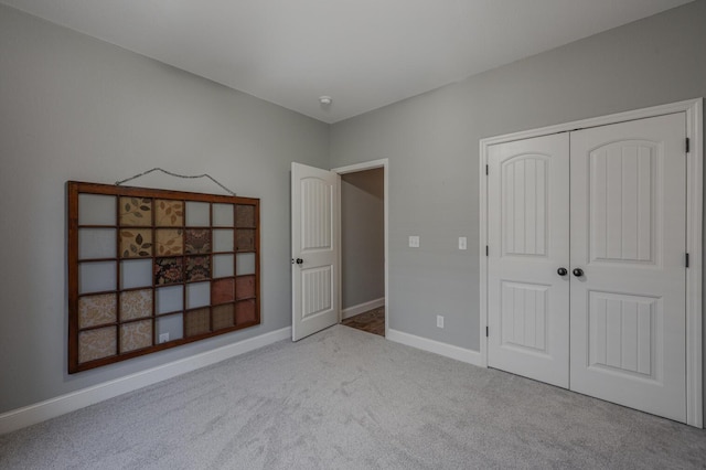 unfurnished bedroom with a closet, carpet flooring, and baseboards