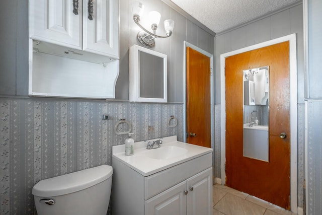 bathroom with tile patterned floors, a textured ceiling, toilet, and vanity