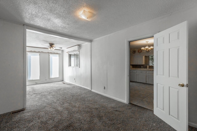 carpeted empty room with ceiling fan with notable chandelier and a textured ceiling