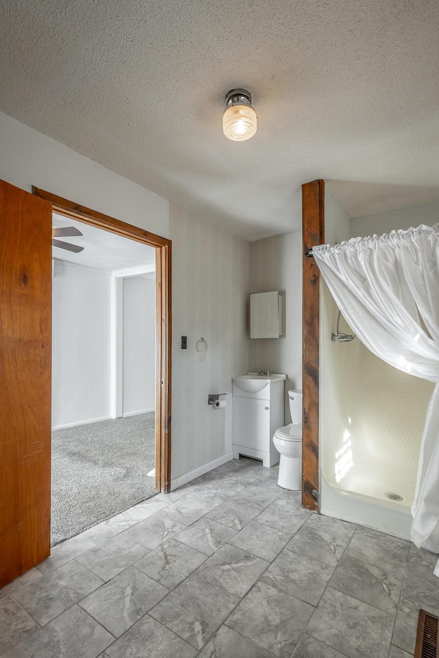 bathroom featuring toilet, a textured ceiling, and vanity