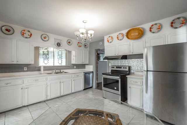 kitchen with tasteful backsplash, white cabinets, appliances with stainless steel finishes, and sink