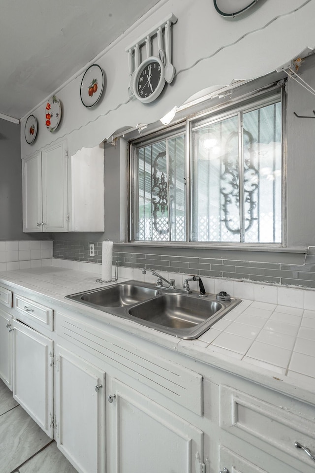 kitchen featuring white cabinets, tasteful backsplash, and sink