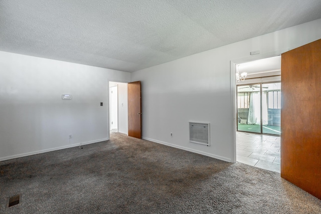 unfurnished room with carpet floors, a fireplace, heating unit, and a textured ceiling