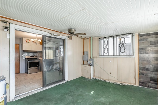 interior space with ceiling fan, light colored carpet, and wooden walls