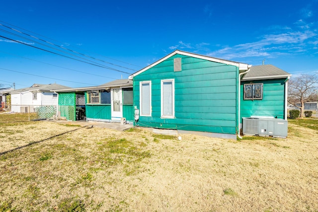 view of front facade with a front yard and central air condition unit