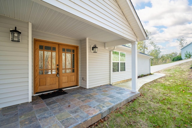 entrance to property featuring a porch and french doors