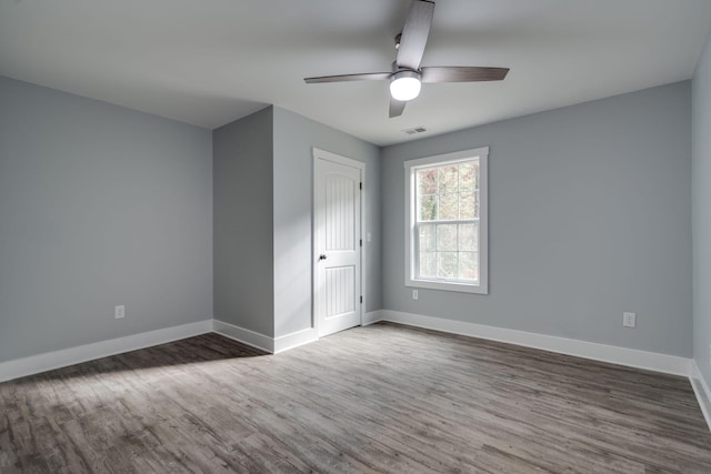 spare room featuring ceiling fan and dark wood-type flooring