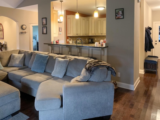 living room featuring sink, dark wood-type flooring, and lofted ceiling