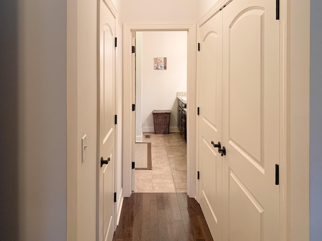 corridor with hardwood / wood-style flooring