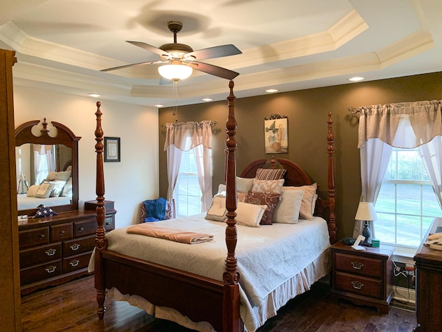 bedroom featuring dark hardwood / wood-style flooring, a raised ceiling, ceiling fan, and crown molding