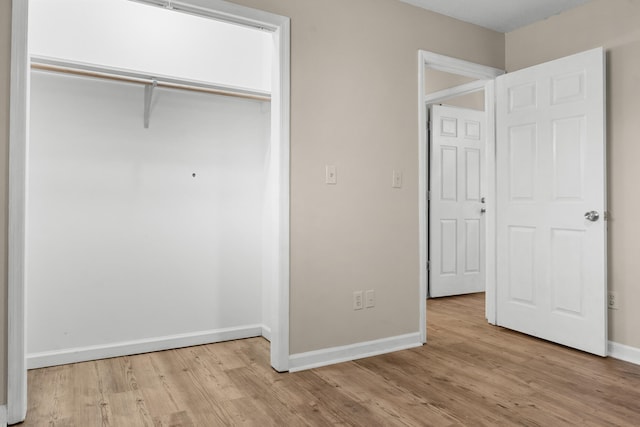 unfurnished bedroom featuring light wood-type flooring and a closet