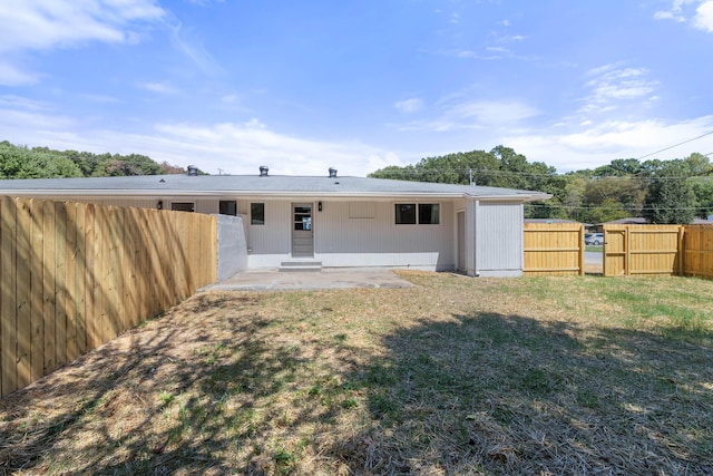 rear view of property featuring a yard and a patio area