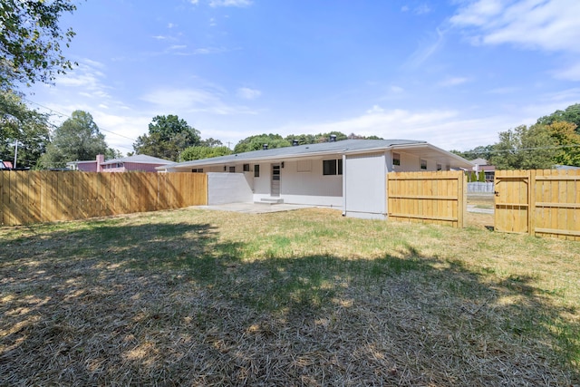 back of property with a yard and a patio