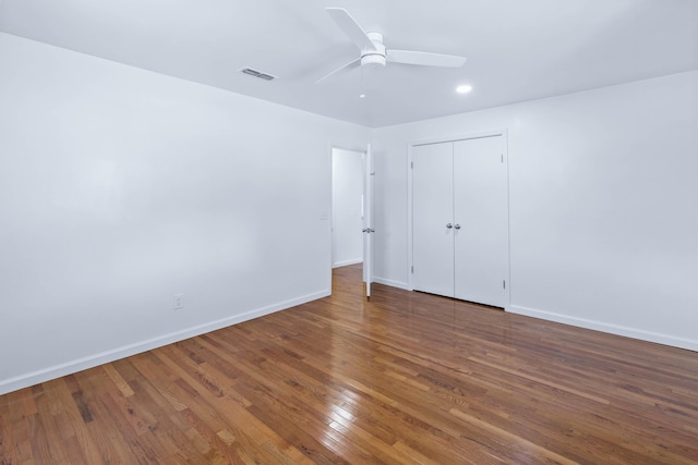 unfurnished bedroom featuring ceiling fan, dark hardwood / wood-style floors, and a closet