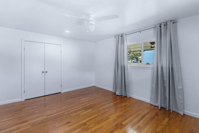 unfurnished bedroom featuring wood-type flooring, a closet, and ceiling fan