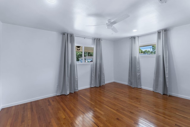 spare room featuring ceiling fan, dark hardwood / wood-style flooring, and a healthy amount of sunlight