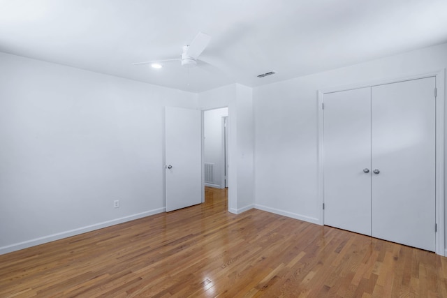 unfurnished bedroom featuring ceiling fan, a closet, and hardwood / wood-style flooring