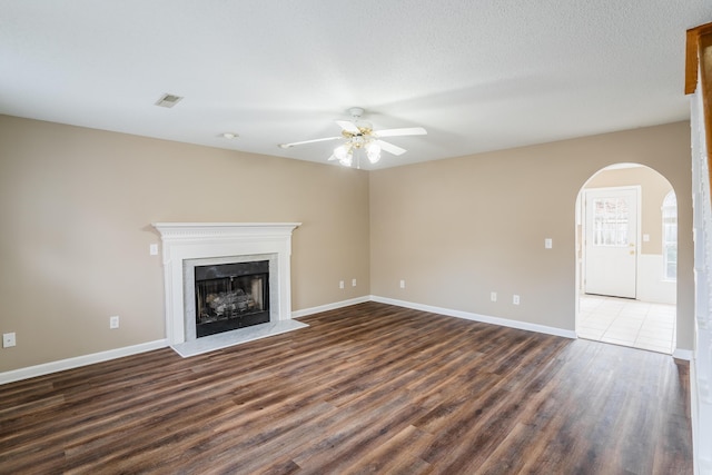 unfurnished living room featuring ceiling fan and dark hardwood / wood-style flooring