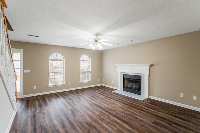 unfurnished living room featuring a textured ceiling, dark hardwood / wood-style flooring, and ceiling fan