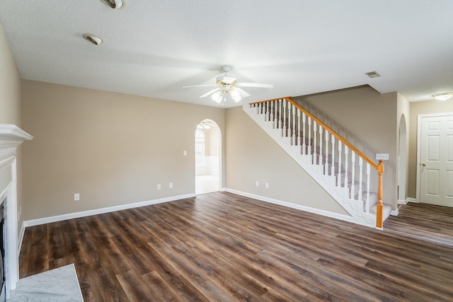 unfurnished living room with dark hardwood / wood-style floors, ceiling fan, and a textured ceiling