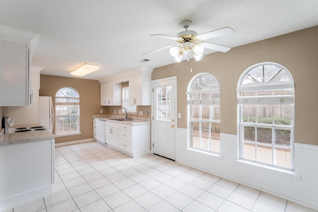 kitchen with a textured ceiling, white appliances, white cabinetry, and sink