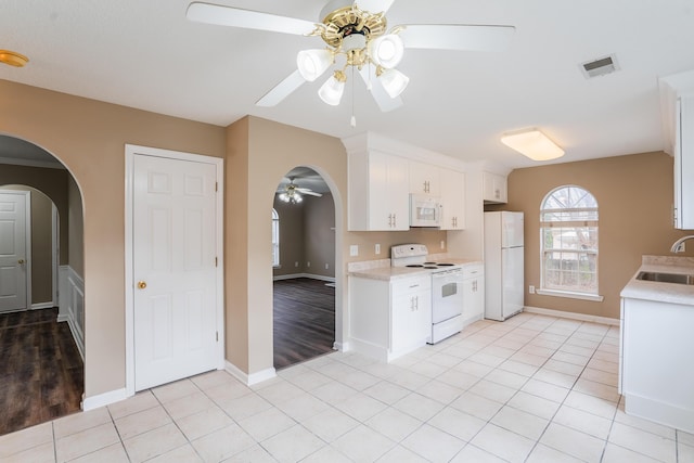 kitchen with white cabinetry, sink, ceiling fan, white appliances, and light tile patterned floors