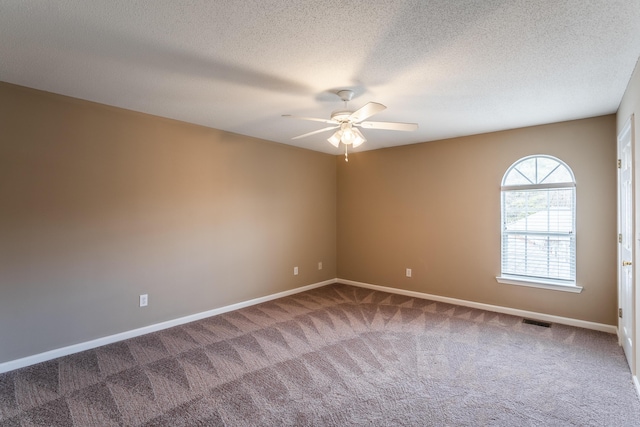 carpeted spare room with ceiling fan and a textured ceiling