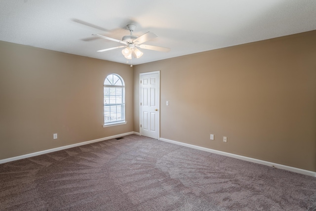 carpeted spare room featuring ceiling fan