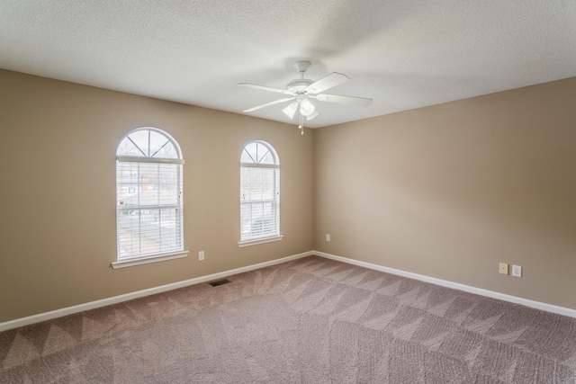 carpeted spare room with ceiling fan and a textured ceiling