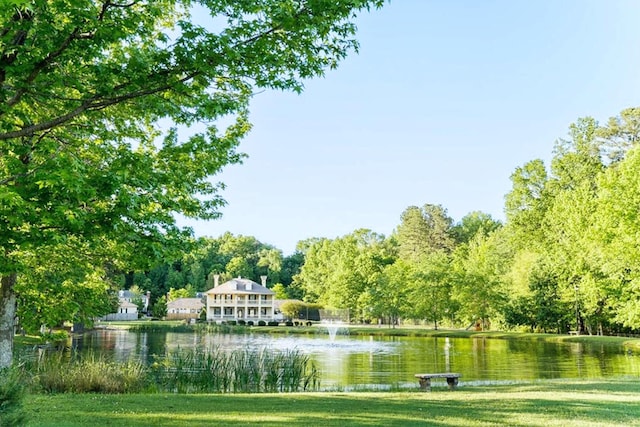 view of community featuring a lawn and a water view