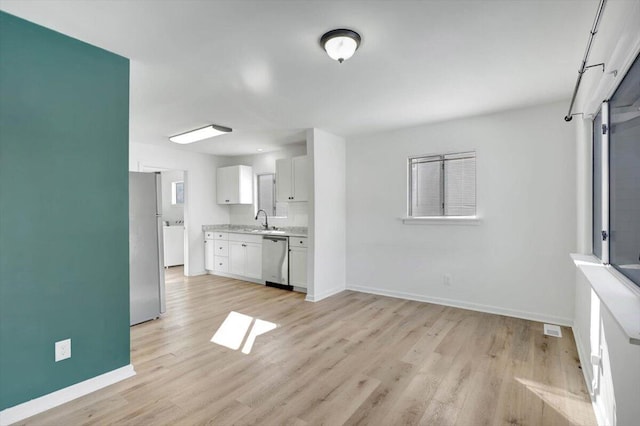 unfurnished living room featuring light wood-type flooring and sink