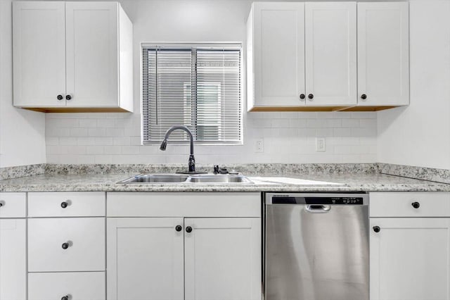 kitchen featuring white cabinets, tasteful backsplash, stainless steel dishwasher, and sink