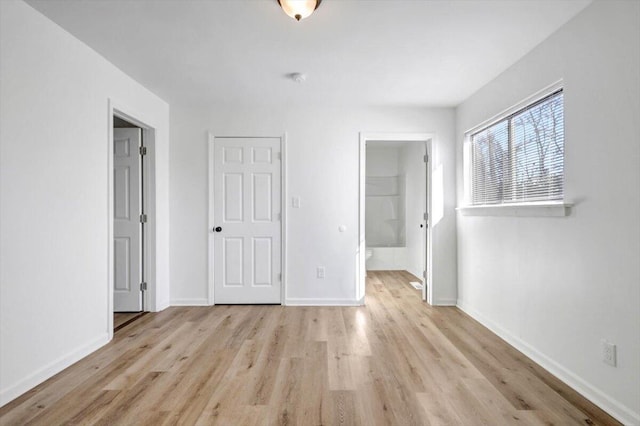 unfurnished bedroom with ensuite bathroom, light hardwood / wood-style floors, and a closet