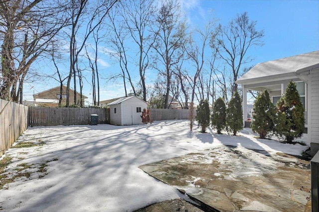 yard layered in snow featuring a storage unit