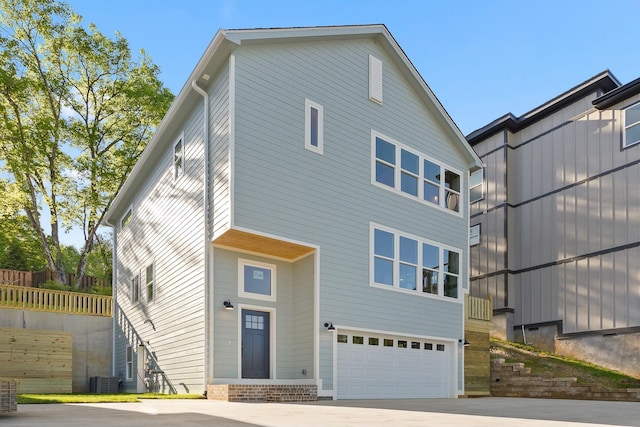 view of front of house featuring a garage and cooling unit