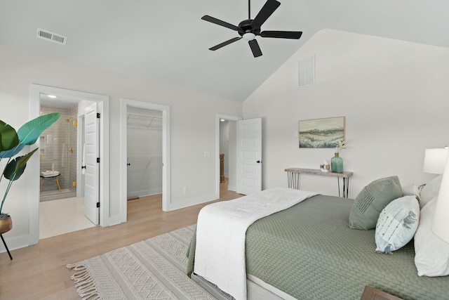 bedroom featuring ensuite bathroom, a walk in closet, light hardwood / wood-style flooring, ceiling fan, and a closet