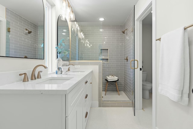 bathroom featuring tile patterned flooring, vanity, toilet, and walk in shower