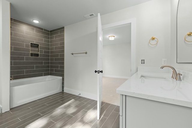 bathroom with vanity and tiled shower / bath