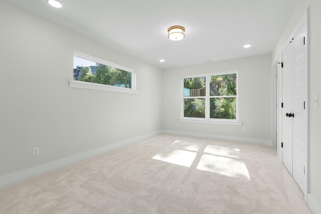 unfurnished room featuring light carpet