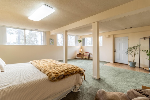 bedroom featuring multiple windows, a textured ceiling, and carpet flooring