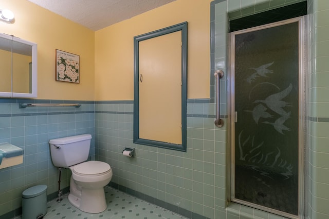 bathroom with walk in shower, tile walls, a textured ceiling, and toilet