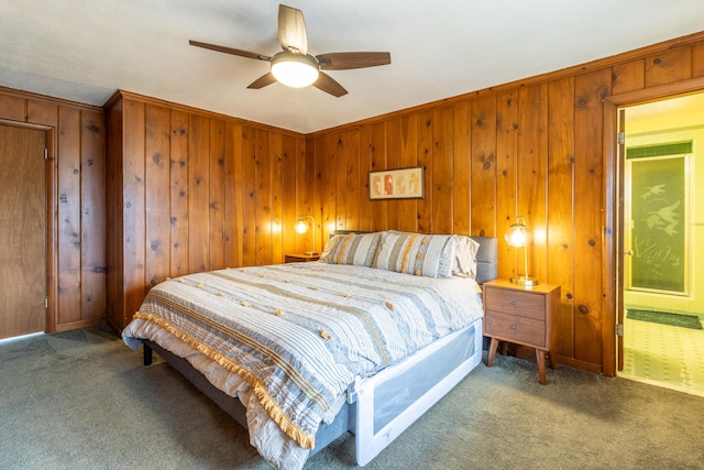 bedroom featuring carpet, ceiling fan, and wood walls