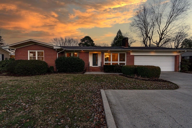 single story home with a garage and a lawn