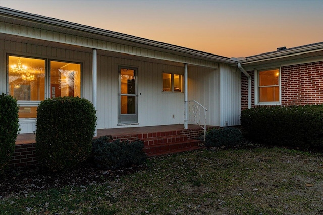 exterior entry at dusk with covered porch