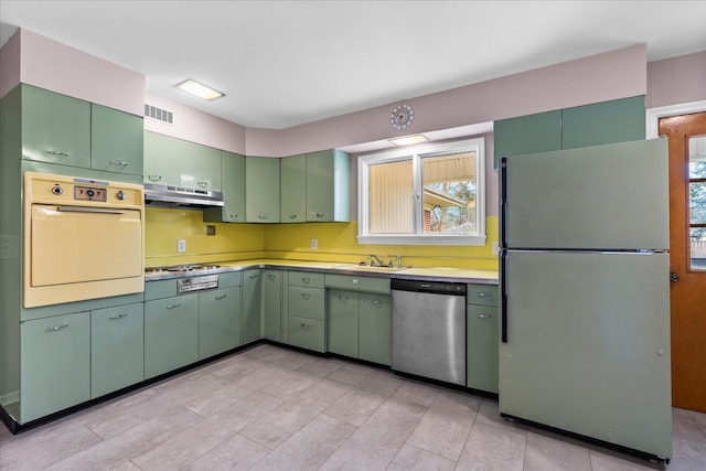 kitchen with stainless steel appliances, green cabinets, and a wealth of natural light