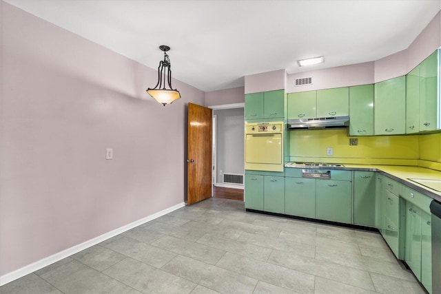 kitchen featuring stainless steel gas cooktop, green cabinets, sink, oven, and decorative light fixtures