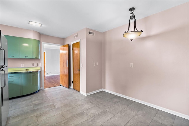 kitchen with green cabinetry and pendant lighting