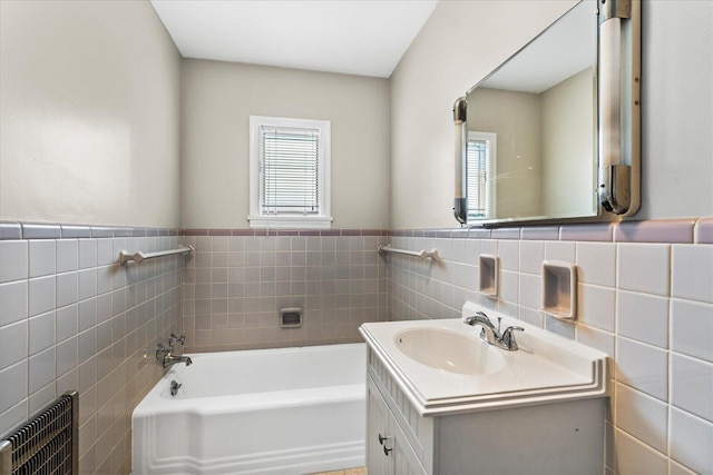 bathroom with a washtub, vanity, radiator, and plenty of natural light